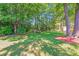 Lush backyard featuring mature trees, green lawn, and storage shed at 15811 Burlingame Dr, Huntersville, NC 28078