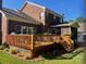 Exterior view of a backyard with a spacious wooden deck, a screened porch, and mature landscaping at 15811 Burlingame Dr, Huntersville, NC 28078