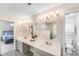 Bathroom with marble countertop, dual sinks, and round mirrors over gray vanities, with a view into the main bedroom at 15811 Burlingame Dr, Huntersville, NC 28078