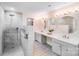 Bright bathroom with dual sinks, marble counters, modern shower with glass door, and gray cabinets at 15811 Burlingame Dr, Huntersville, NC 28078