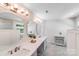 Bright bathroom with modern lighting, double sinks with marble countertop and gray cabinets and oval mirrors at 15811 Burlingame Dr, Huntersville, NC 28078