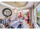 Elegant dining room with a chandelier, mirror, and a view to a bright, adjoining room filled with sunlight at 15811 Burlingame Dr, Huntersville, NC 28078