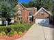 Charming two-story brick home with a well-manicured lawn, inviting curb appeal, and an attached two car garage at 15811 Burlingame Dr, Huntersville, NC 28078