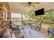 Covered screened porch featuring ceiling fan, comfortable seating, and TV for outdoor enjoyment at 15811 Burlingame Dr, Huntersville, NC 28078