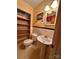 Well-maintained bathroom features a toilet, sink, tiled walls and an open shelving unit at 211 S Slack St, Albemarle, NC 28001