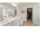 Well-lit bathroom with double vanity, white cabinetry, and a glass-enclosed shower, plus walk-in closet at 2439 Judson Dr, Gastonia, NC 28054