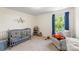 Bright Bedroom features a grey crib, soft carpet and a serene window view at 2439 Judson Dr, Gastonia, NC 28054