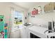 Bright laundry room equipped with modern washer, dryer, storage shelves, and a window with natural light at 2439 Judson Dr, Gastonia, NC 28054