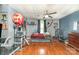Bedroom boasts a twin bed, wood floors, ceiling fan, and ample space for activities at 300 S Hudson Ave, Spencer, NC 28159