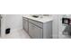 Clean bathroom featuring a double sink vanity with gray cabinets, white marble floor, and a modern design at 3115 Hutton Gardens Ln, Charlotte, NC 28269