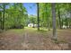 This large backyard offers mature trees and leads to a well-kept home with white siding and dark roof shingles at 316 Wade Hampton Dr, Matthews, NC 28104