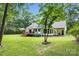 Sprawling backyard featuring a deck with a white umbrella and room for entertaining nestled amongst mature trees at 316 Wade Hampton Dr, Matthews, NC 28104