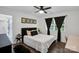 Bright bedroom with a cozy bed, wood floors, and natural light from a nearby window at 316 Wade Hampton Dr, Matthews, NC 28104