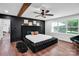 Stylish main bedroom featuring a black accent wall, large bed, hardwood floors, and a cozy seating area at 316 Wade Hampton Dr, Matthews, NC 28104