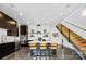 Modern kitchen features an island with seating, sleek cabinetry, stainless steel appliances, and open staircase at 3304 Mar Vista Cir, Charlotte, NC 28209