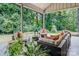 Covered patio featuring stylish outdoor furniture surrounded by lush greenery, ideal for relaxing or entertaining at 3304 Mar Vista Cir, Charlotte, NC 28209
