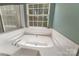 Inviting soaking tub surrounded by white tile and a window offering a relaxing view at 4000 Garfield Ct, Waxhaw, NC 28173