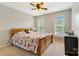 Comfortable bedroom with a wooden bed frame, ceiling fan, and bright natural light from two windows at 4000 Garfield Ct, Waxhaw, NC 28173