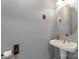 Charming powder room featuring a pedestal sink, round mirror, and decorative fixtures at 4000 Garfield Ct, Waxhaw, NC 28173