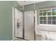 Shower features glass doors, showerhead, and soap rack with natural light from the nearby window at 4000 Garfield Ct, Waxhaw, NC 28173