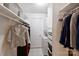 Organized closet featuring built-in shelving and a stacked washer/dryer unit at 4736 Hedgemore Dr, Charlotte, NC 28209