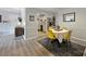 Charming dining room with a round table, four yellow chairs, and wood-look flooring at 4736 Hedgemore Dr, Charlotte, NC 28209