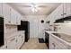 Well-lit kitchen featuring white cabinets and tiled countertops at 4736 Hedgemore Dr, Charlotte, NC 28209