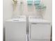 Convenient laundry room equipped with a washer, dryer, and storage shelf at 5008 Patton Dr, Gastonia, NC 28056