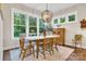 Light-filled dining room features large windows, a rustic wooden table, and stylish light fixture at 501 Preservation Dr, Fort Mill, SC 29715
