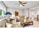 A cozy living room featuring a leather sofa, ceiling fan, and a glimpse of the hallway at 501 Preservation Dr, Fort Mill, SC 29715