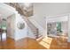 Open foyer with hardwood floors, staircase with dark metal railings, and living room views at 512 Appomatox Dr, Marvin, NC 28173