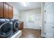 Well-equipped laundry room with modern washer and dryer, cabinets, and access to backyard at 512 Appomatox Dr, Marvin, NC 28173