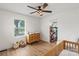 Bright Bedroom featuring a wooden crib, natural wood dresser, wood-look flooring, and modern ceiling fan at 5740 Crouse Rd, Crouse, NC 28033