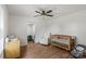 Bright Bedroom featuring a wooden crib, neutral glider, wood-look flooring, and modern ceiling fan at 5740 Crouse Rd, Crouse, NC 28033