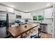 Well-lit kitchen features stainless steel appliances, white cabinetry, and a wooden dining table at 5740 Crouse Rd, Crouse, NC 28033