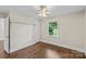 Bedroom with neutral colored walls, hardwood flooring, ceiling fan and attached closet at 5811 Gettysburg Dr, Concord, NC 28027
