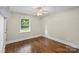 Bedroom with hardwood flooring, ceiling fan and neutral colored walls with bright white trim at 5811 Gettysburg Dr, Concord, NC 28027