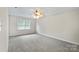 A spacious bedroom features neutral paint, plush carpet, and ample natural light from the window at 5811 Gettysburg Dr, Concord, NC 28027