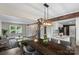 Open-concept dining area with modern lighting, hardwood floors, and a view of the kitchen at 5811 Gettysburg Dr, Concord, NC 28027