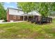 Exterior elevation of the brick house, white siding, dark deck, covered patio, and green lawn at 5811 Gettysburg Dr, Concord, NC 28027