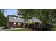 Exterior elevation features the back of a brick house, white siding, covered patio, and dark back deck at 5811 Gettysburg Dr, Concord, NC 28027