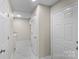 Neutral hallway featuring marble floors, white doors, and access to the laundry room at 5811 Gettysburg Dr, Concord, NC 28027