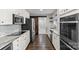 A modern kitchen featuring granite countertops, stainless steel appliances, white cabinetry, and a sliding barn door at 5811 Gettysburg Dr, Concord, NC 28027