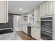 Modern kitchen featuring granite countertops, white cabinetry, stainless steel appliances, and a sliding barn door at 5811 Gettysburg Dr, Concord, NC 28027