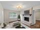 Bright living room with a decorative fireplace, hardwood floors, and large windows at 5811 Gettysburg Dr, Concord, NC 28027