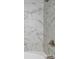 A close up of a tiled shower featuring marble-like tiles and silver fixtures at 5811 Gettysburg Dr, Concord, NC 28027