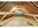 Unfinished attic space with exposed wooden beams and a window for natural light at 629 Wingrave Dr, Charlotte, NC 28270