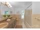 Full bath boasts a double vanity, large mirror, and a glass enclosed shower with a window view at 629 Wingrave Dr, Charlotte, NC 28270
