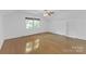 Large bedroom with hardwood floors, ceiling fan, built-in bookcase, and natural light at 629 Wingrave Dr, Charlotte, NC 28270