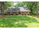 Charming brick home with a well-maintained lawn, lush landscaping, and mature trees at 629 Wingrave Dr, Charlotte, NC 28270
